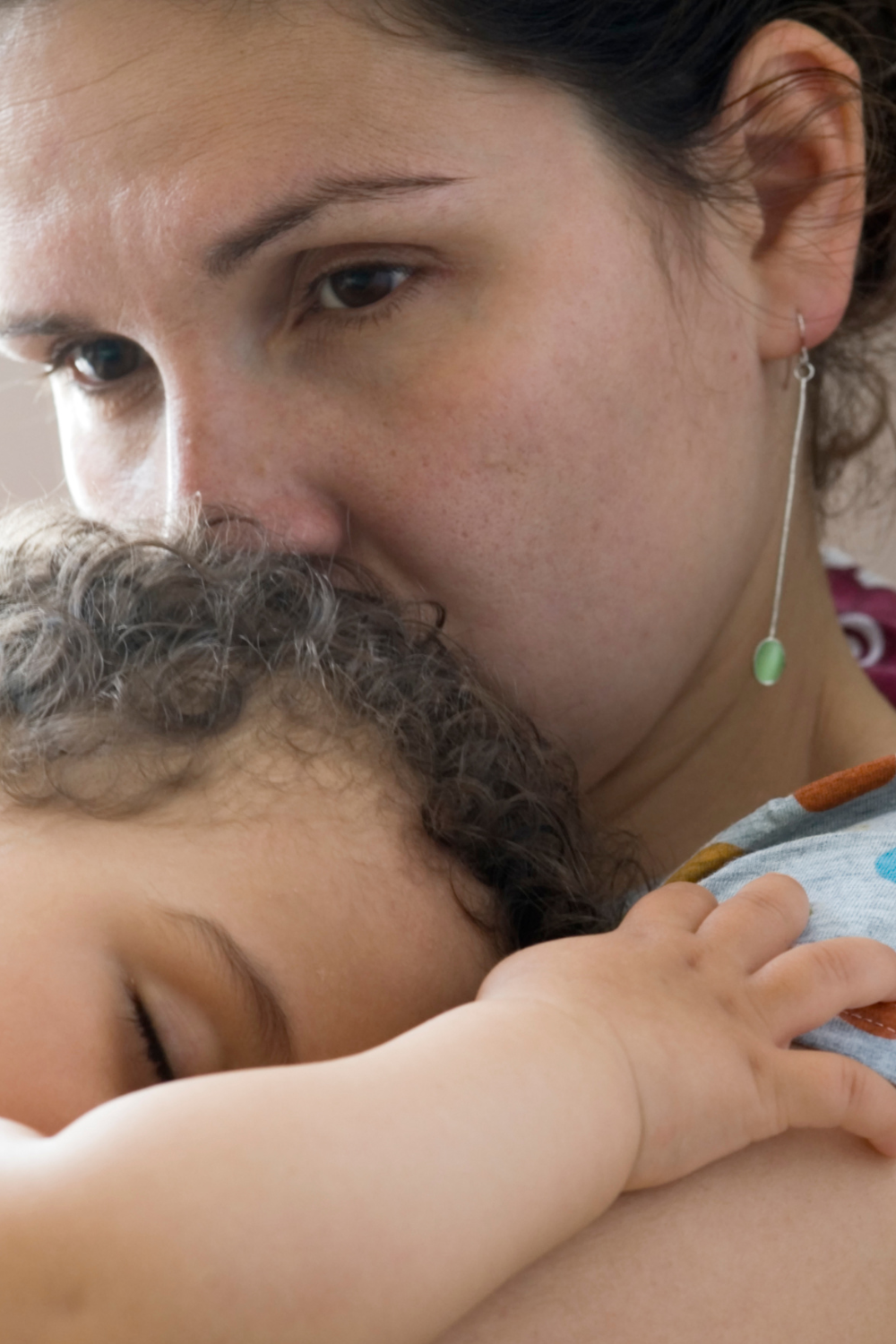 Mum holding a baby whilst her brain is working overtime with worry 